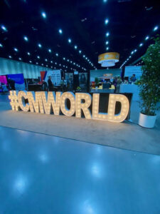 A light up sign featuring the phrase #CMWORLD.