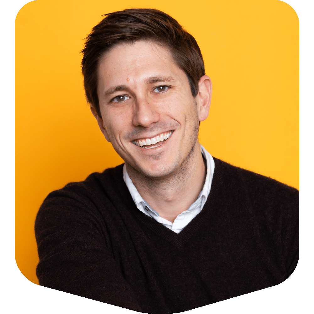 Matt Schur, Senior Content Manager, smiling in a professional headshot against a vibrant yellow background.